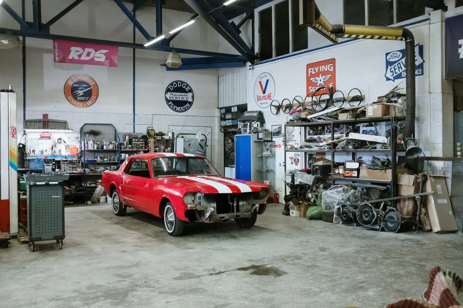 Atelier de restauration de voiture ancienne avec outils et pièces détachées