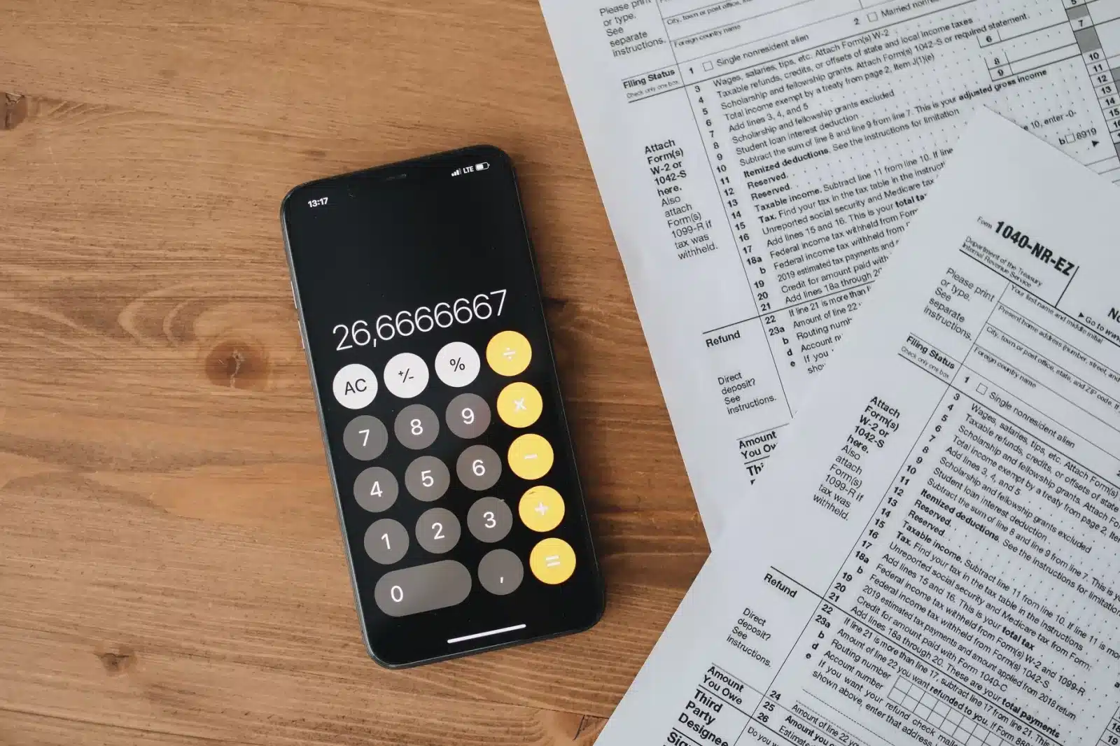 Calculatrice, documents de taxe CO2 et clé de voiture sur une table en bois