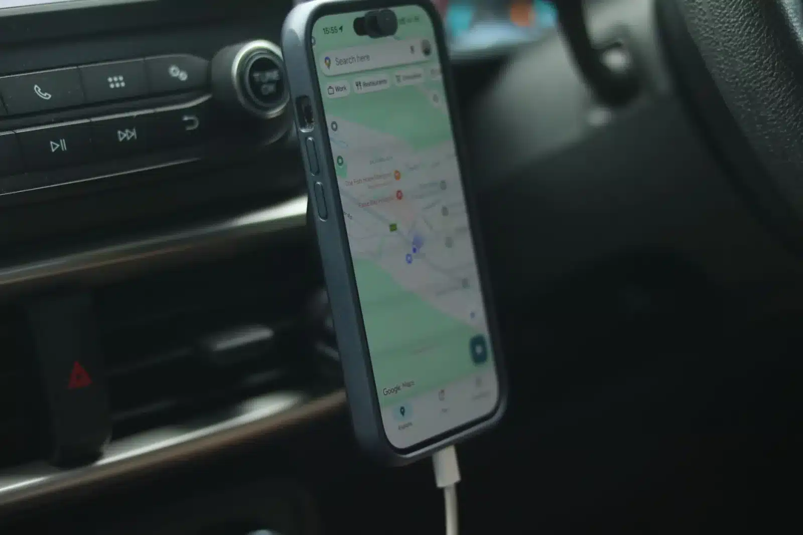 Chargeur à induction pour voiture fixé sur un tableau de bord avec smartphone en recharge