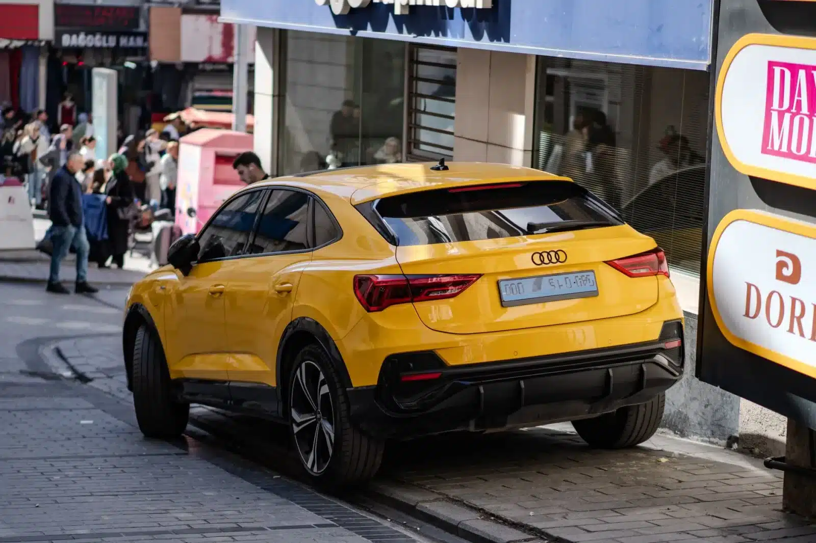 Citadine polyvalente garée dans une rue animée, illustrant son usage urbain et quotidien