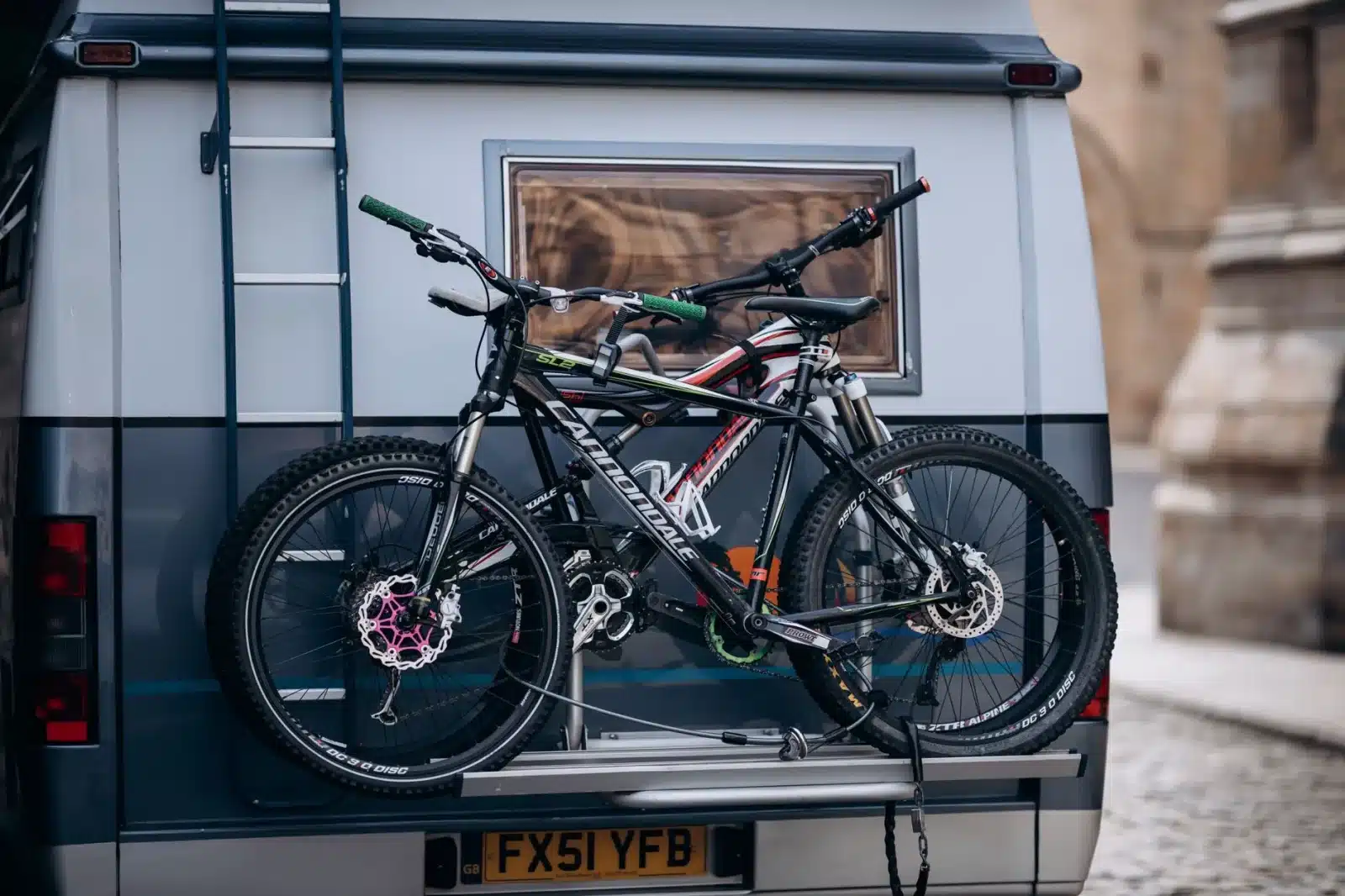 Couple chargeant des vélos dans un fourgon aménagé au lever du jour