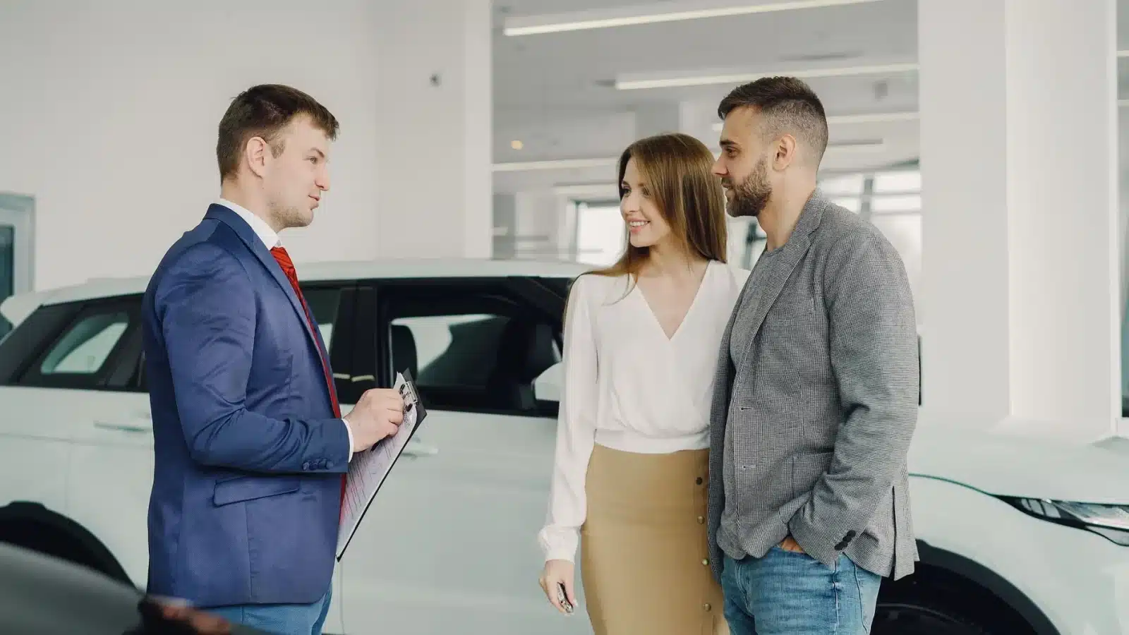 Couple en discussion avec un vendeur pour l'achat d'une voiture neuve