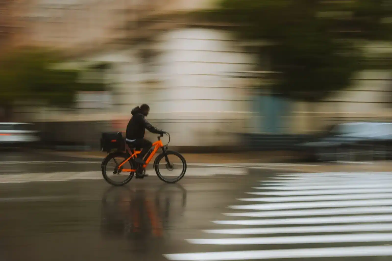 Cycliste roulant sur un vélo électrique en ville sous la pluie