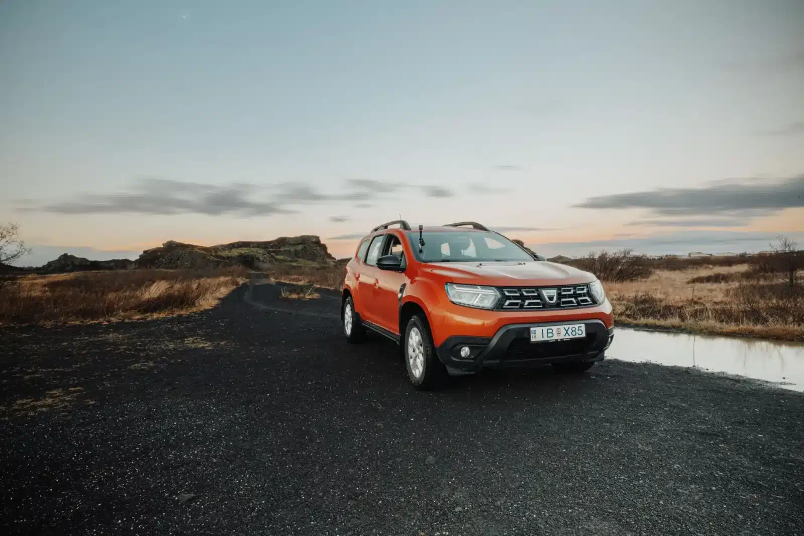 Dacia Duster bleue en situation tout-terrain avec coffre chargé
