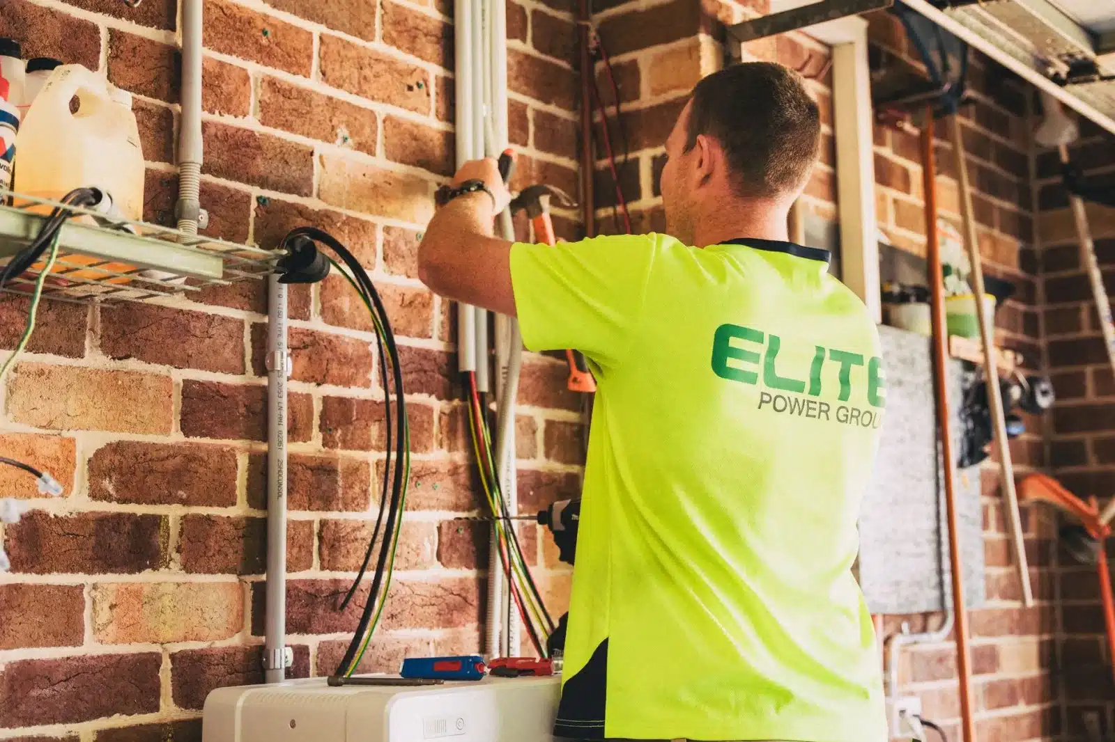 Électricien installant une wallbox 7kW sur le mur extérieur d'une maison