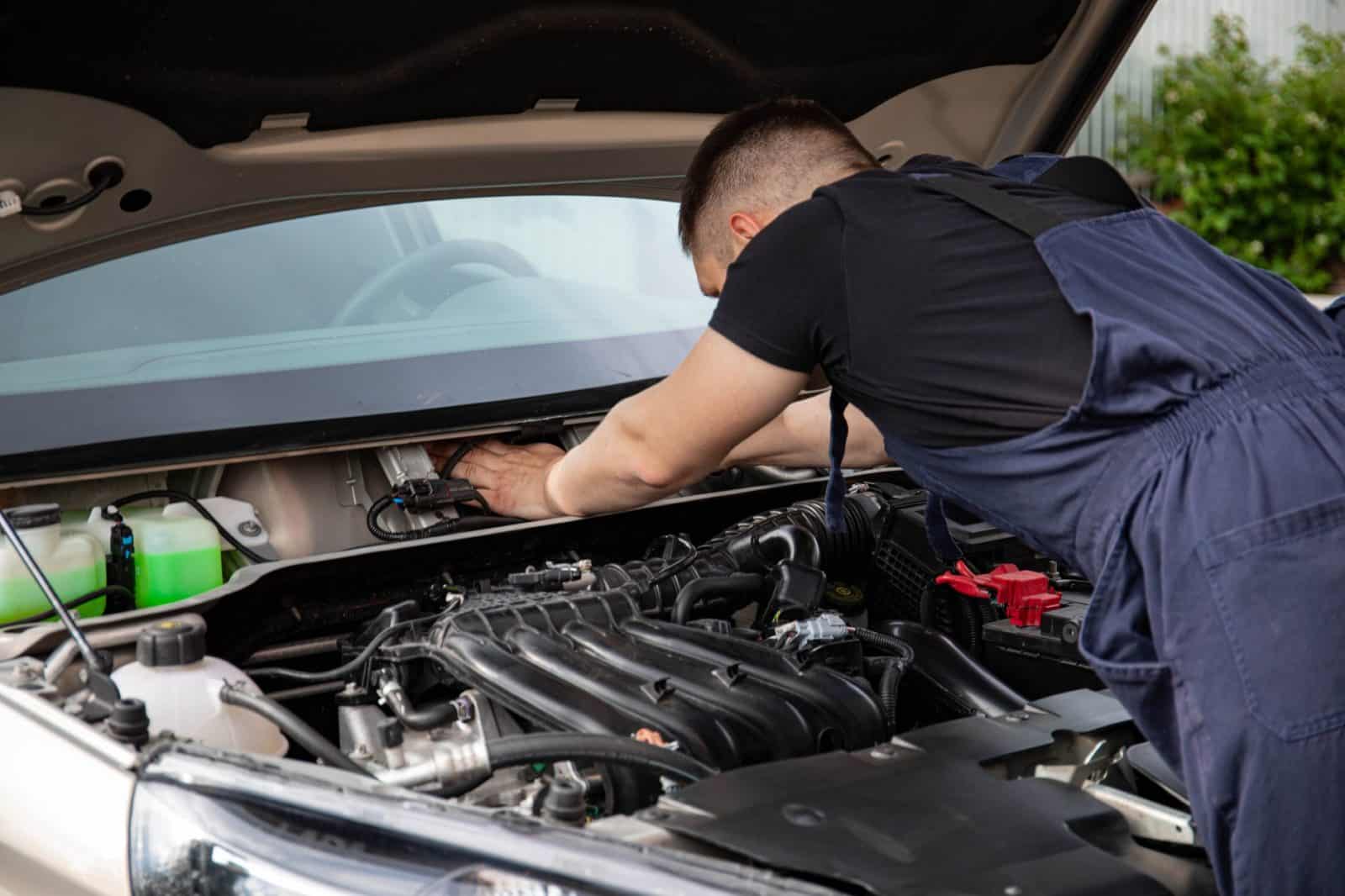 Mecanicien realisant l'entretien d'une voiture au garage