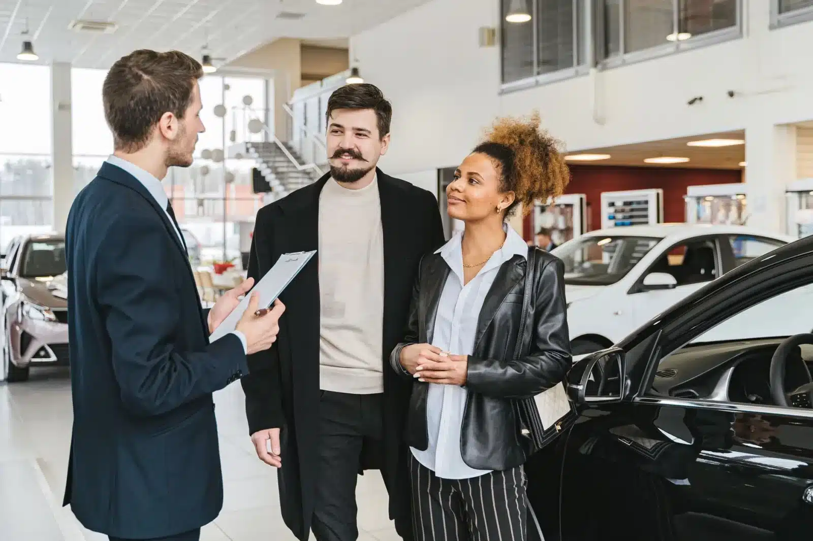 Famille comparant des contrats de leasing LOA et LLD chez un concessionnaire