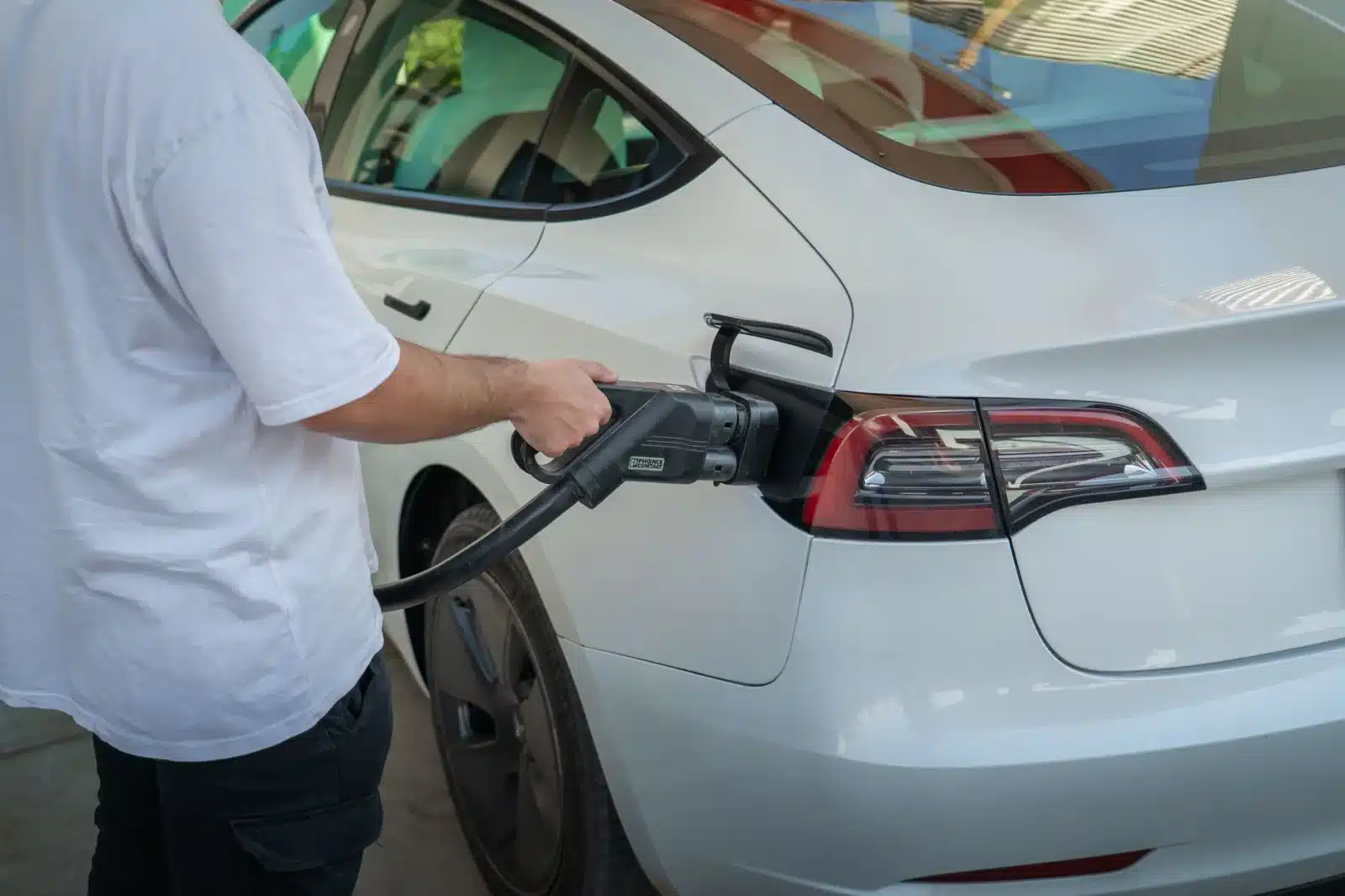 Famille rechargeant une voiture électrique à domicile avec bonus écologique