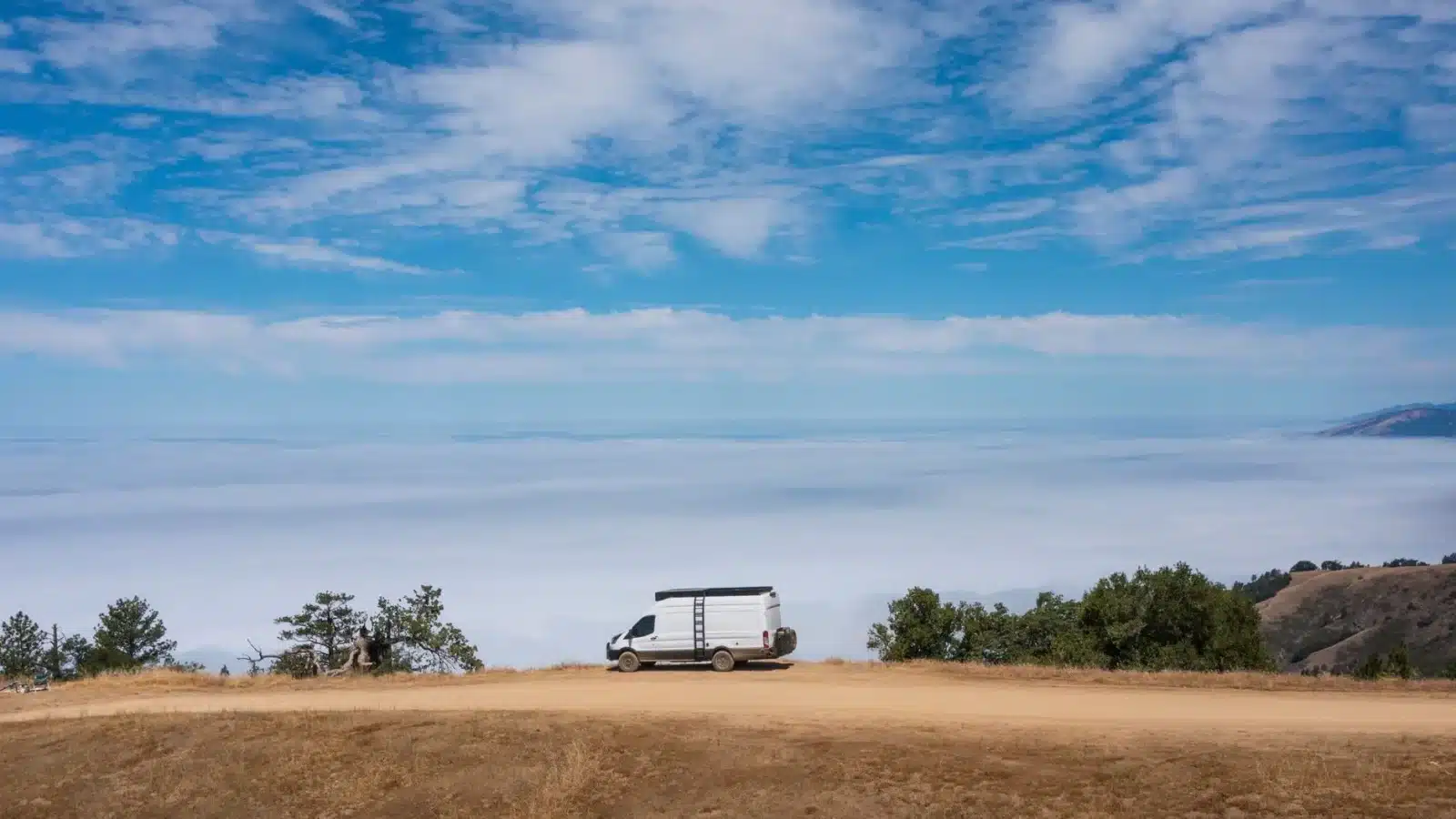 Fourgon utilitaire blanc roulant sur une route de campagne