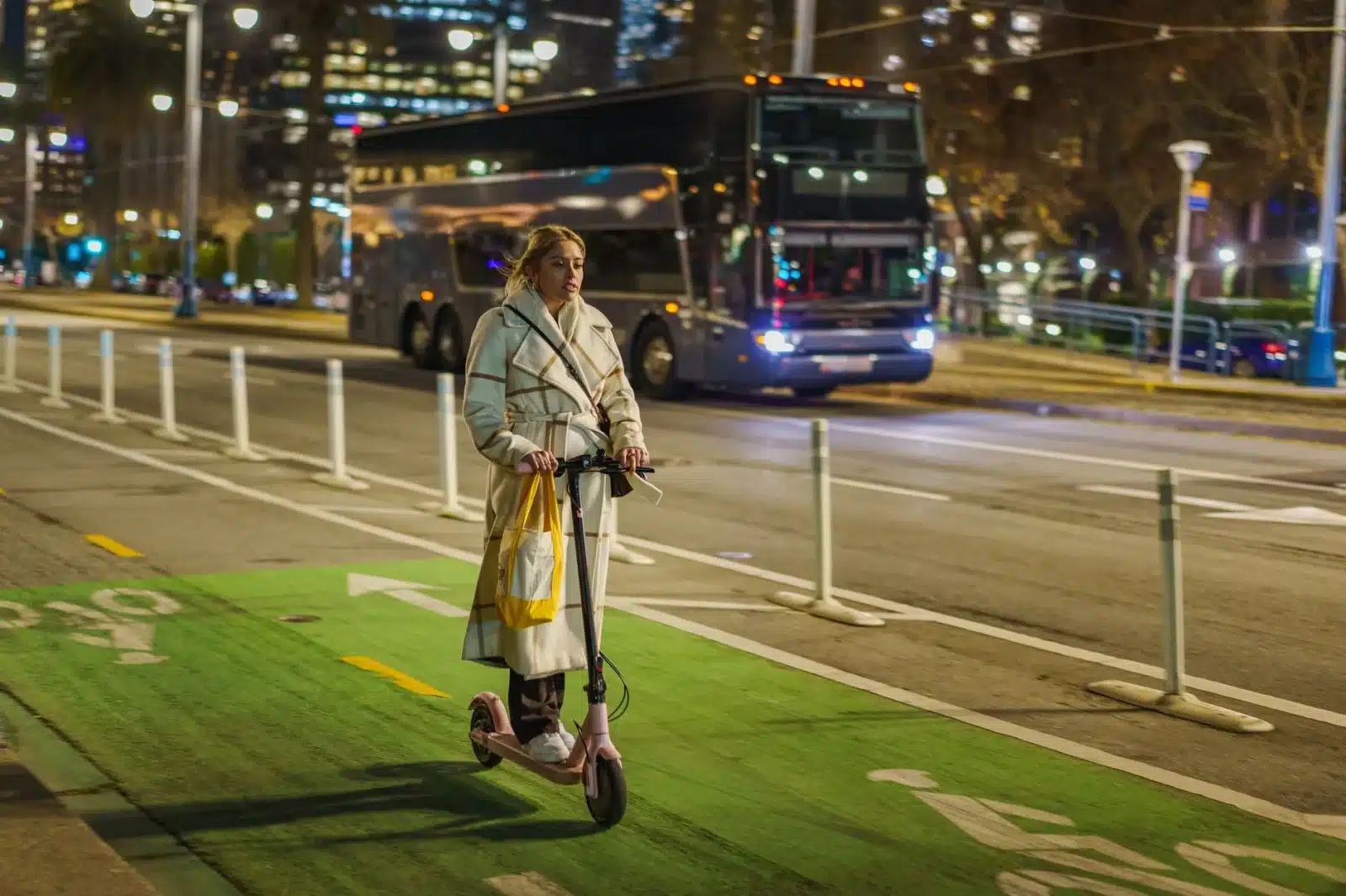 Jeune circulant en trottinette électrique sur une piste cyclable en ville