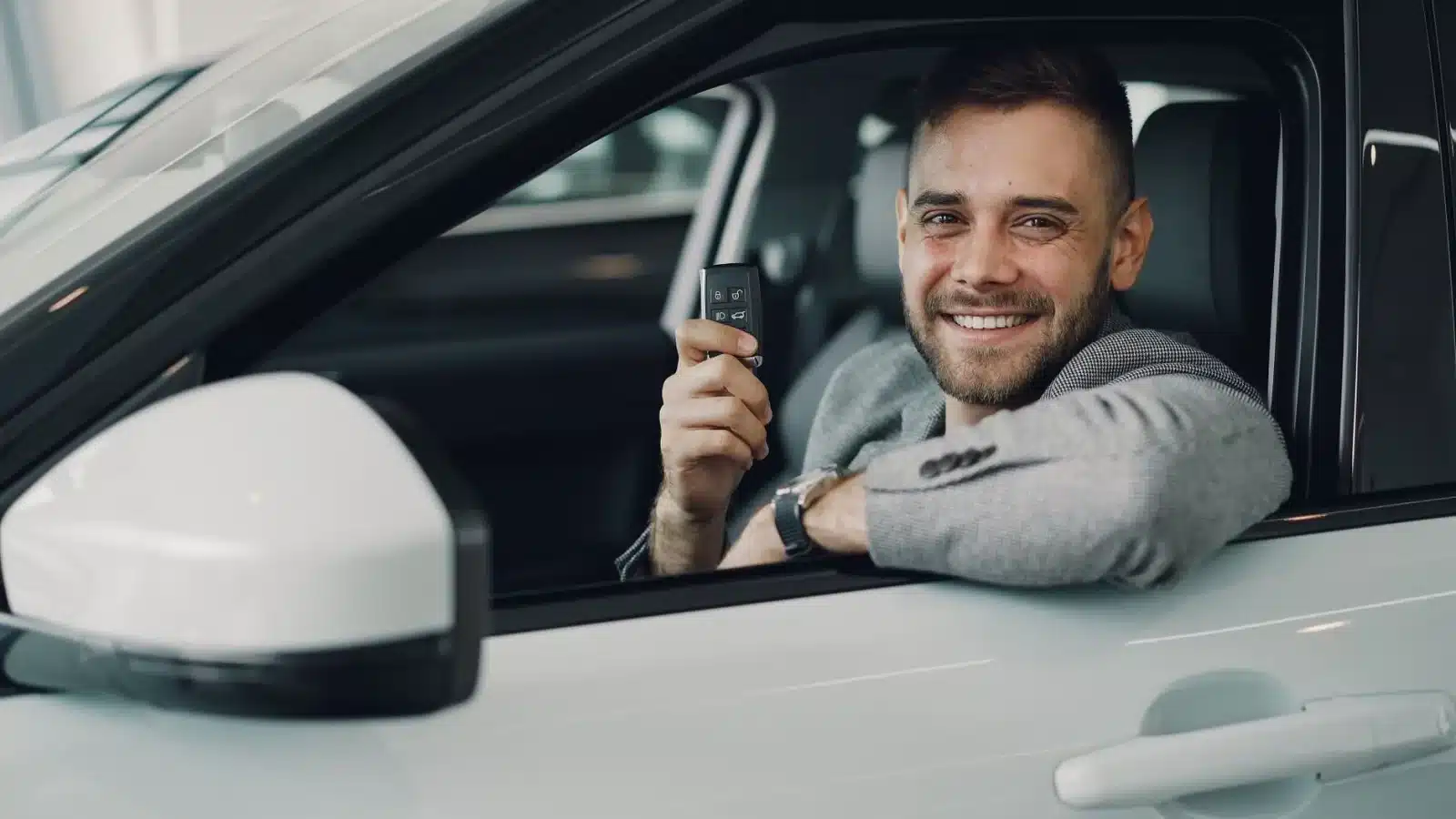 Jeune conducteur tenant les clés de sa première voiture