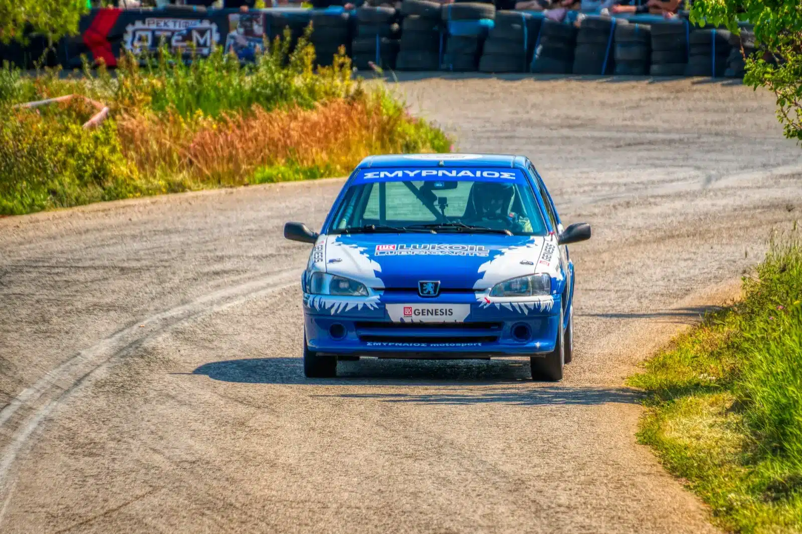 Jeune pilote débutant en voiture de rallye avec un instructeur, école FFSA, circuit ensoleillé