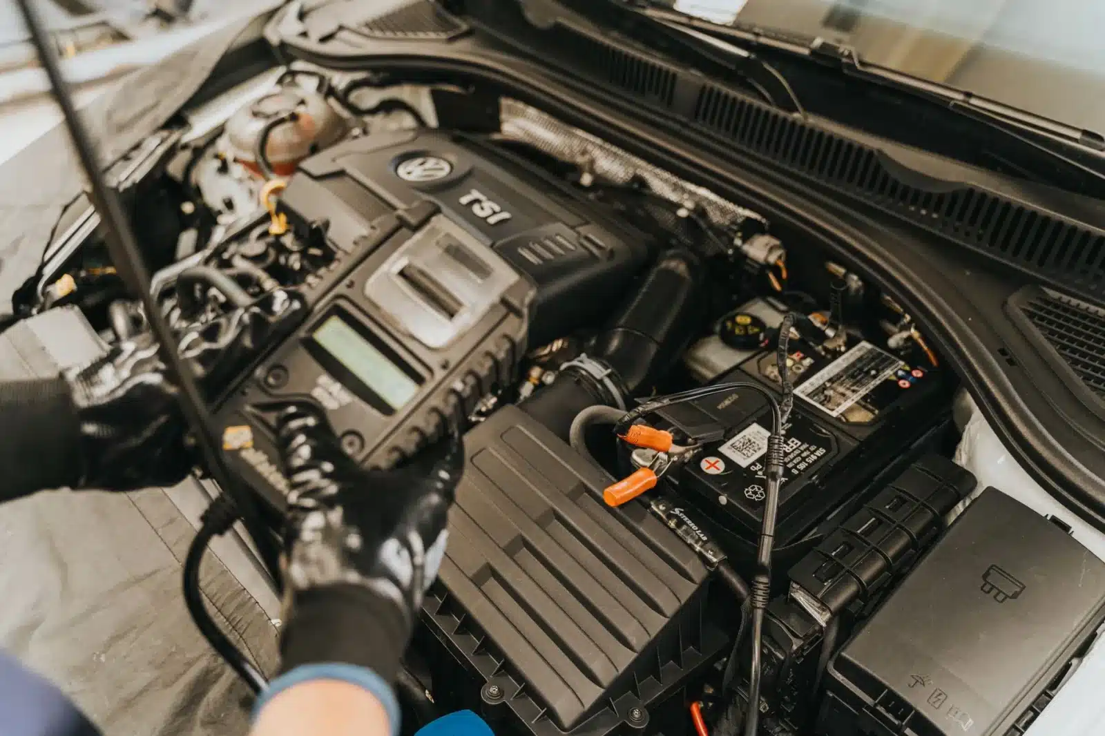 Mécanicien inspectant le moteur d'une voiture allemande dans un garage