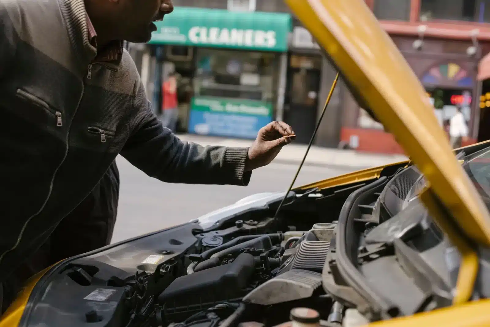 Mécanicien inspectant le moteur d'une voiture d'occasion pour détecter un vice caché