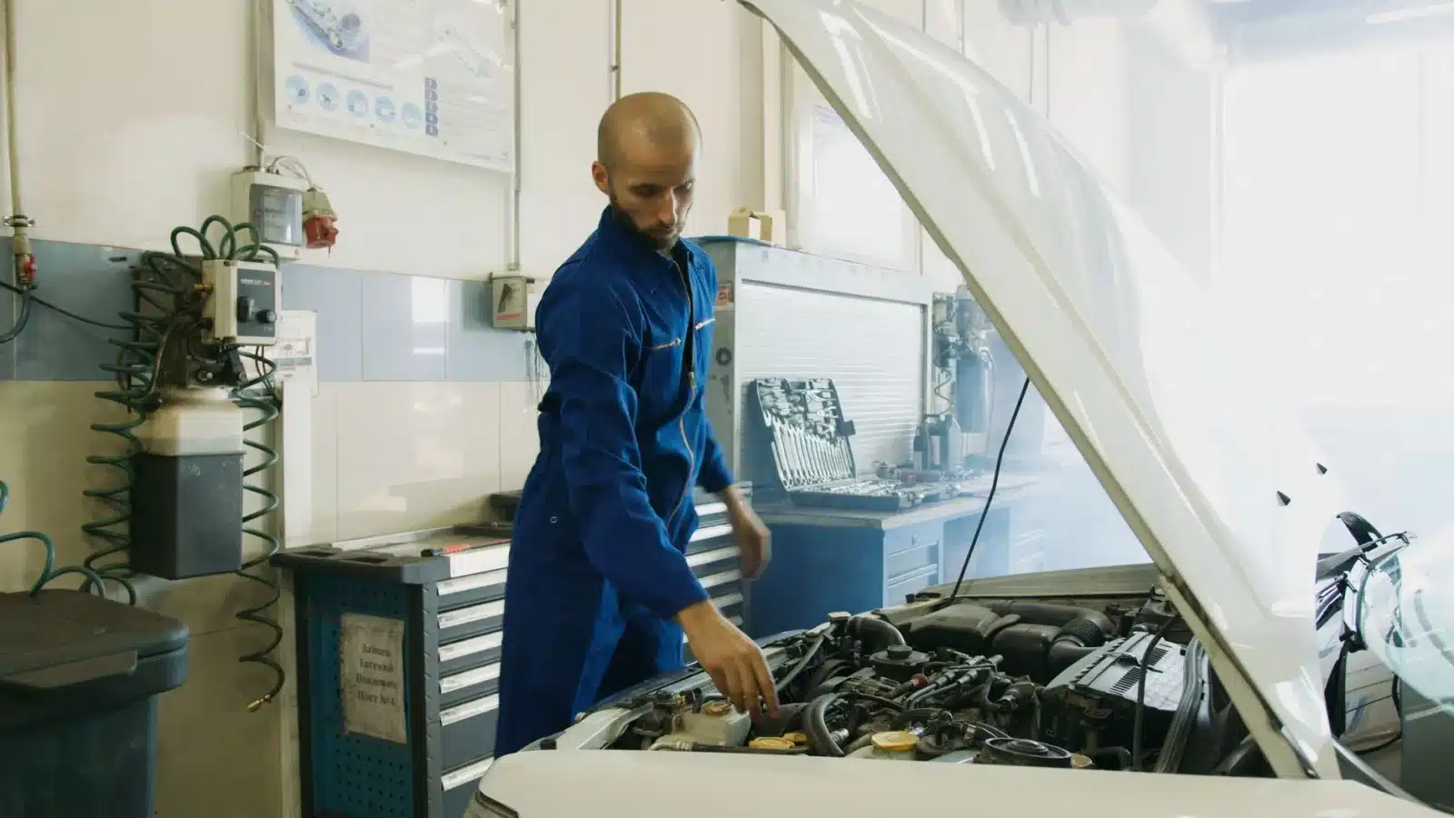 Mécanicien inspectant le moteur d'une voiture dans un garage