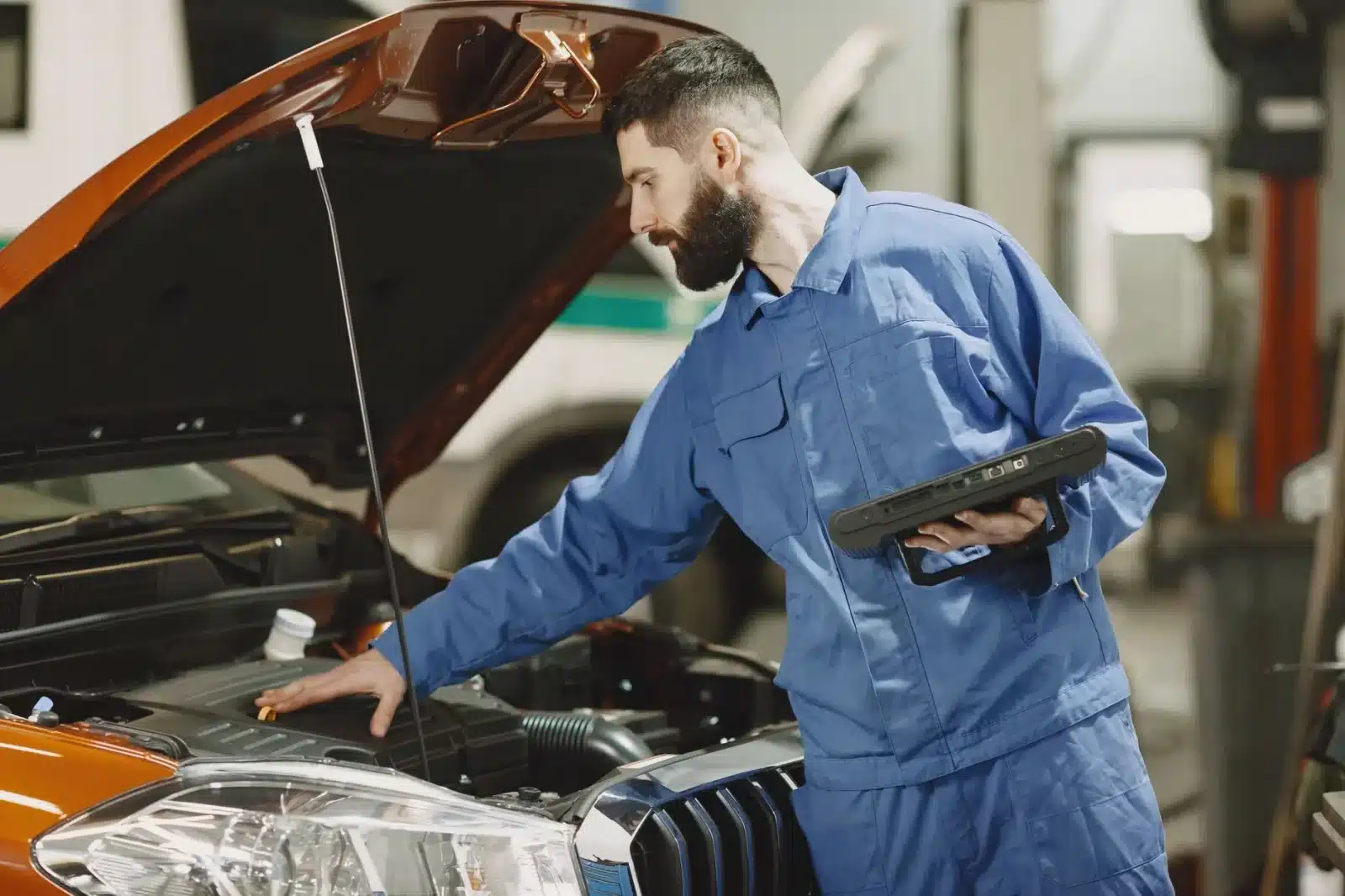 Mécanicien lisant un code défaut OBD sur le tableau de bord d'une voiture avec voyant moteur allumé