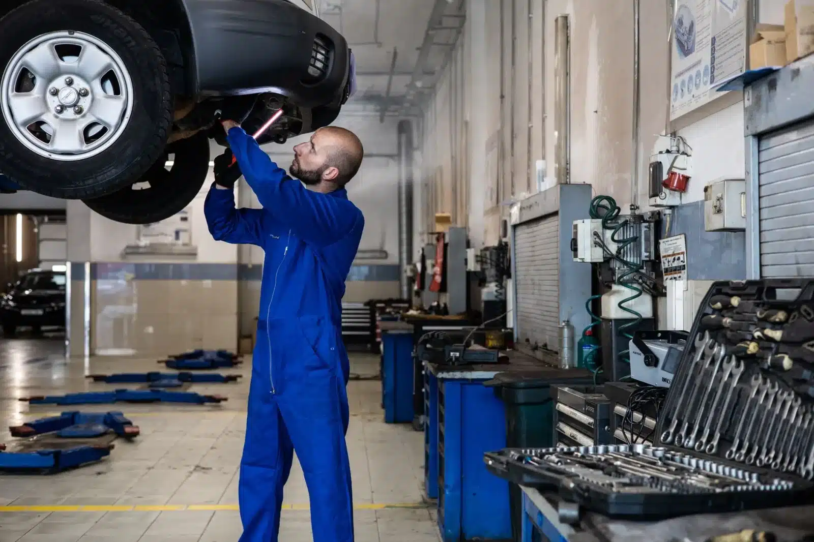 Mécanicien travaillant sur une voiture électrique chinoise dans un atelier moderne