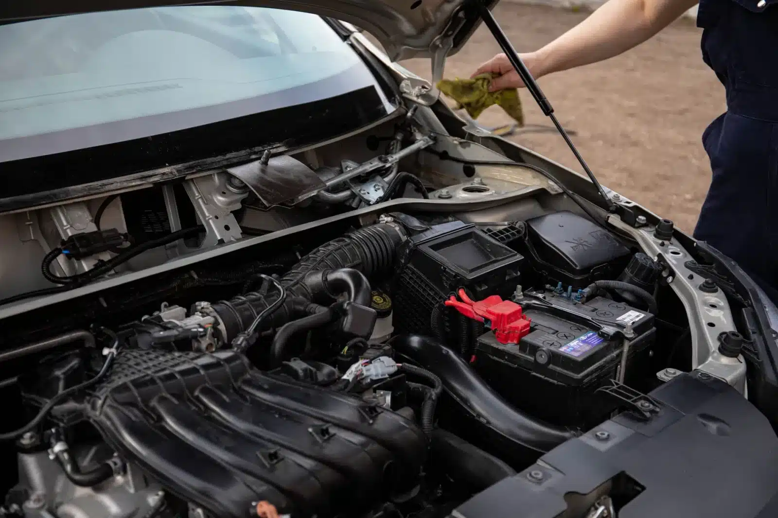 Mécanicien vérifiant le pack de batterie d'une voiture hybride d'occasion au garage