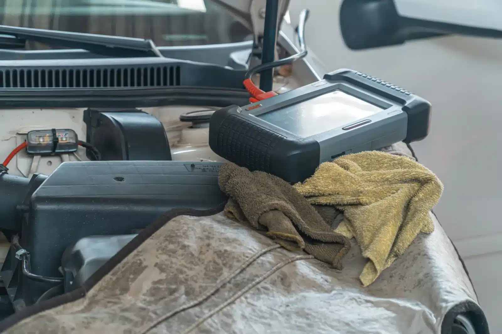 Mécanicien vérifiant un voyant moteur orange avec une valise OBD