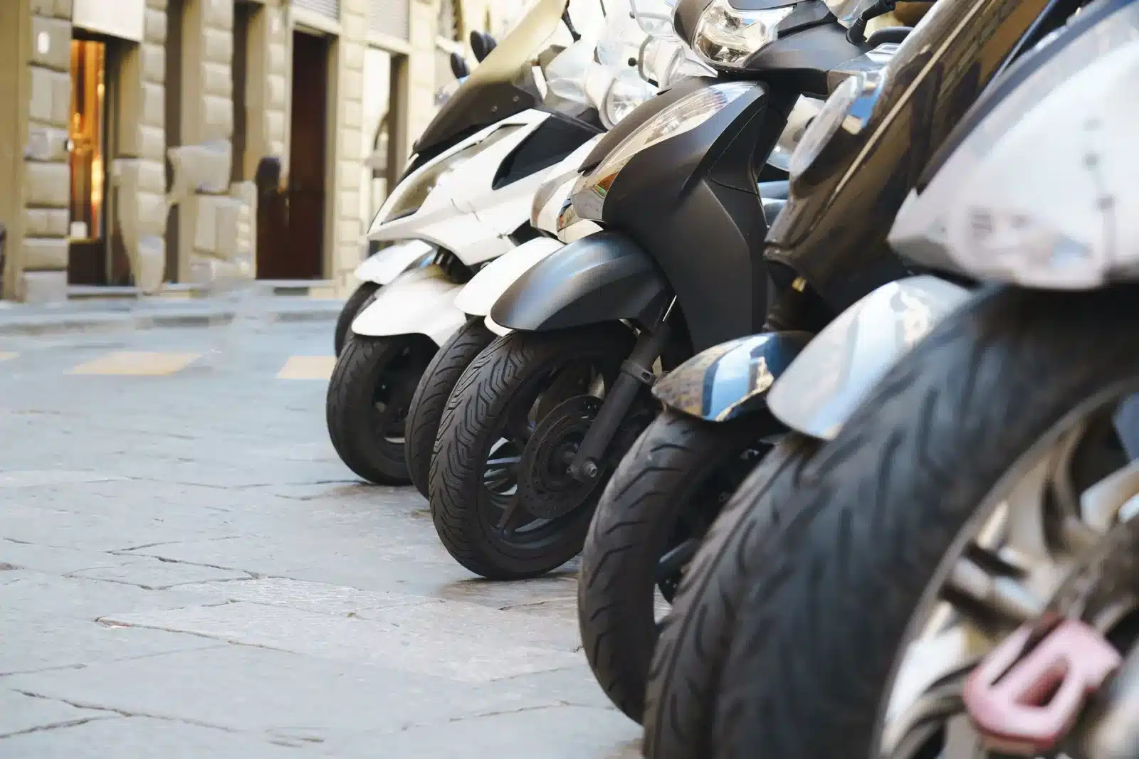 Motos et scooters garés côte à côte dans une rue de ville