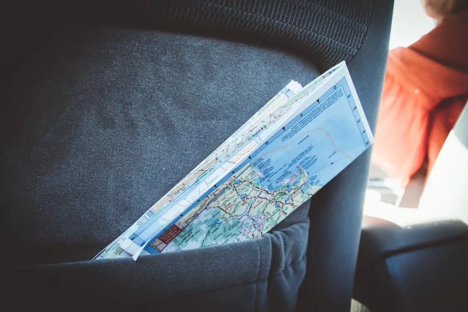 Papiers du véhicule et clés posés sur une carte d'Europe pour préparer un road trip