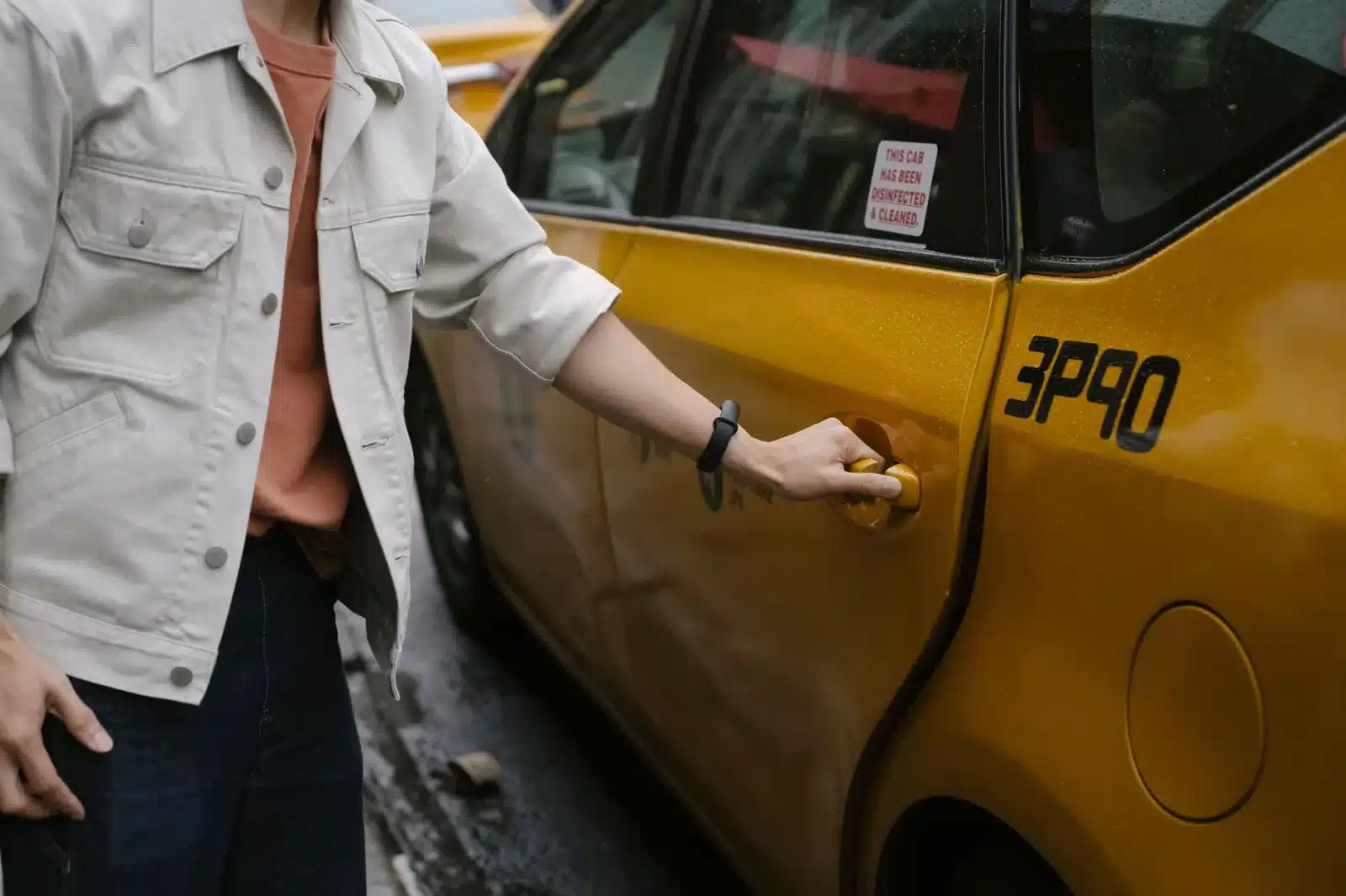 Passager montant dans un VTC un soir de pluie en ville