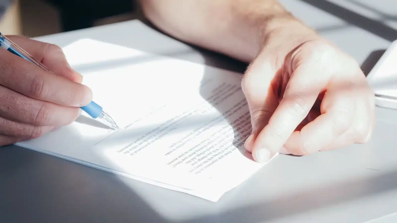 Personne signant une carte grise barrée avec la mention 'vendu'
