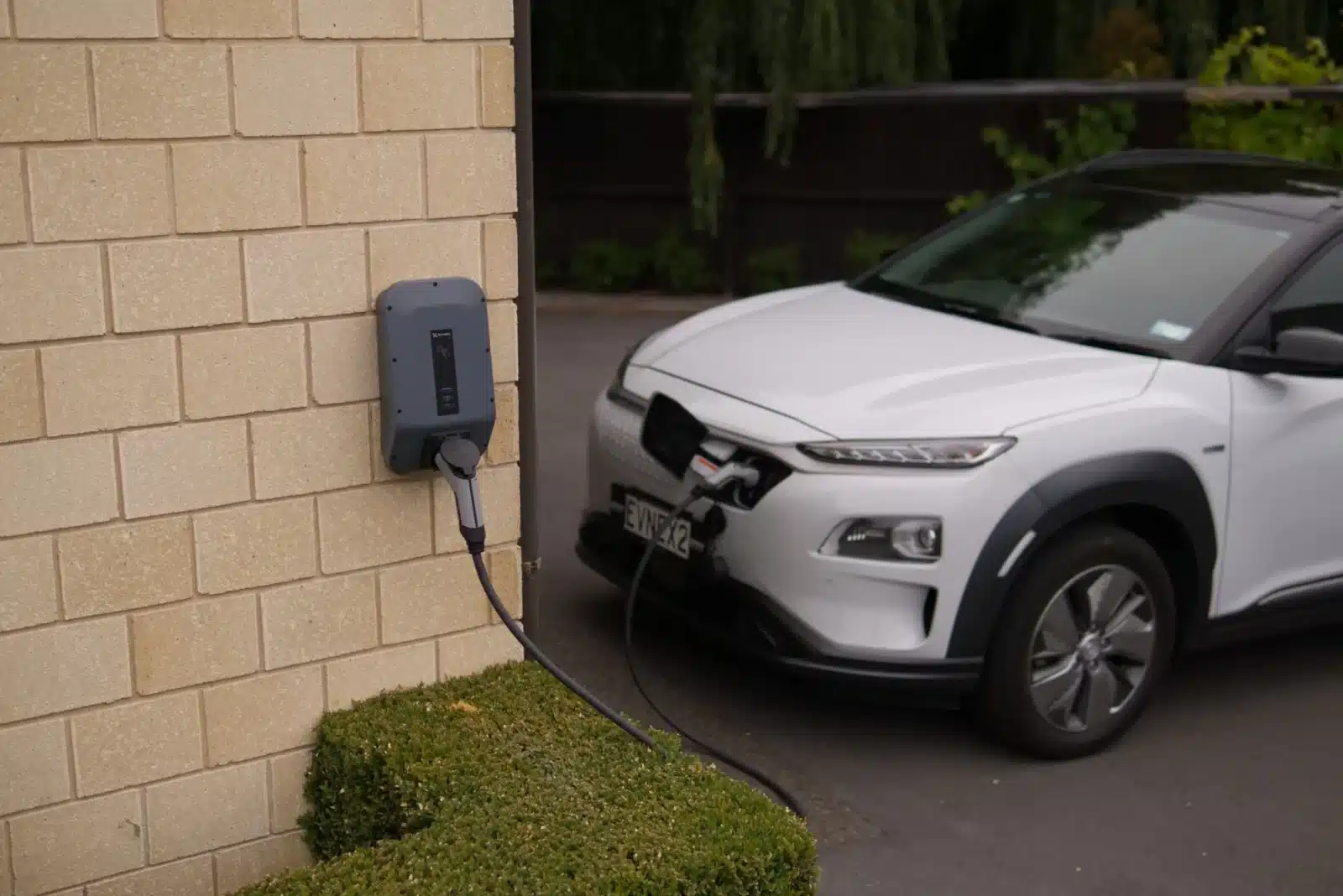 Petite voiture électrique branchée sur une borne de recharge à domicile