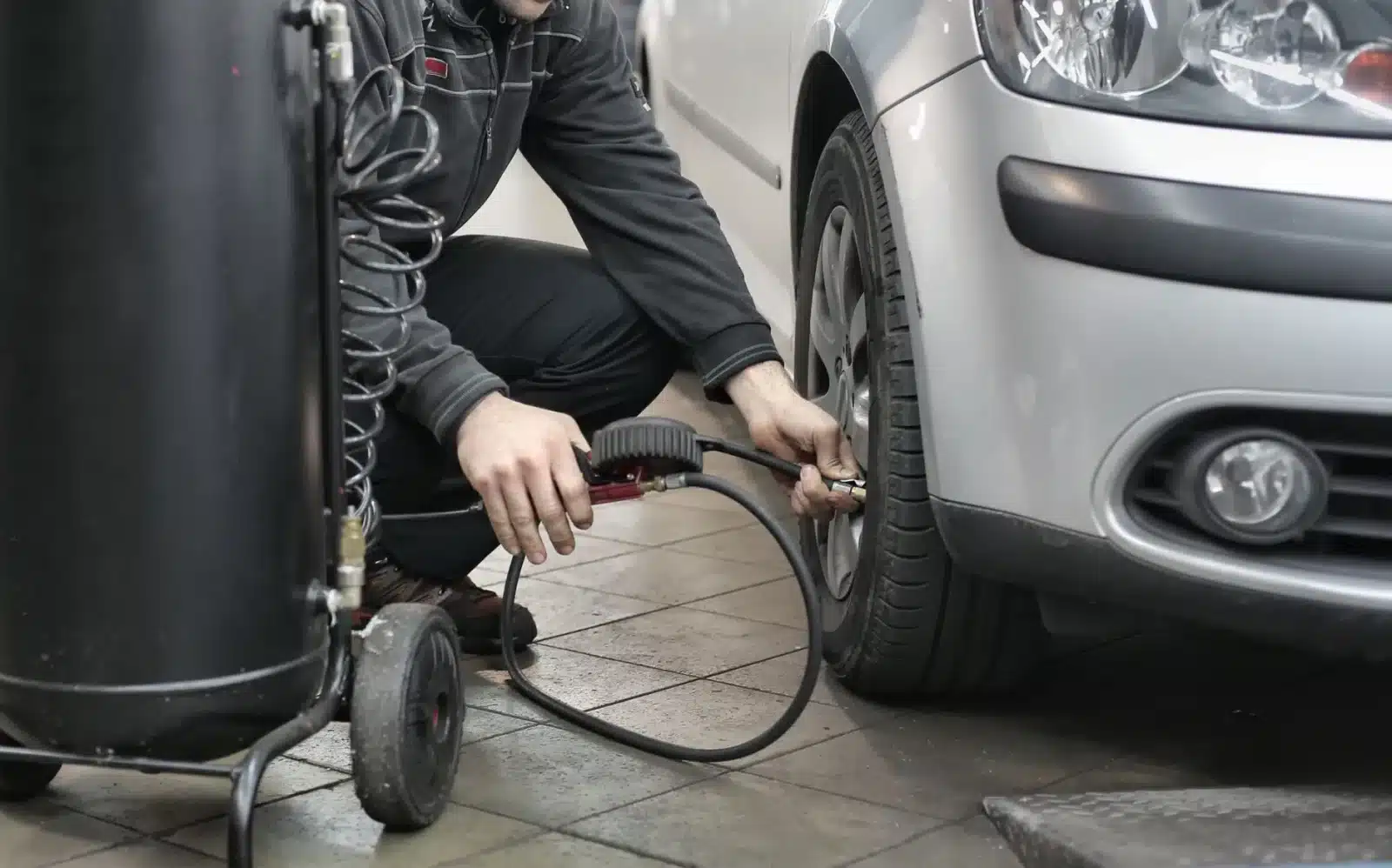 Propriétaire vérifiant la pression des pneus avant un contrôle technique