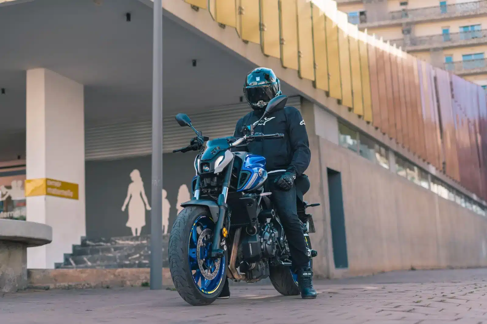 Roadster Yamaha MT-07 garé en ville avec un motard en équipement casual