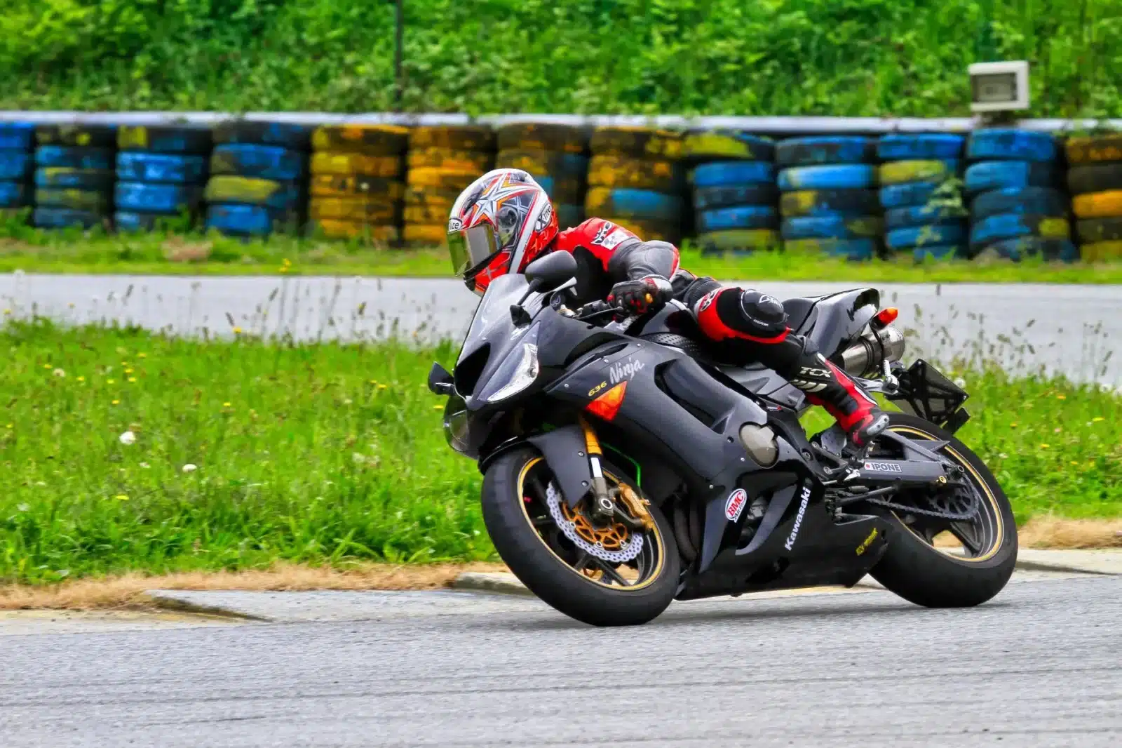 Sportive Kawasaki Ninja ZX-4RR sur circuit avec pilote en combinaison de course