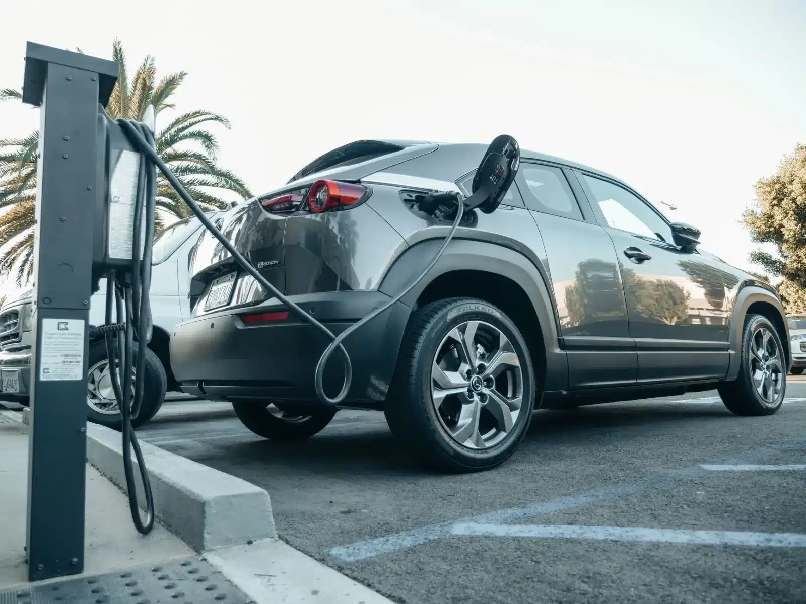 SUV électrique garé devant une station de recharge rapide