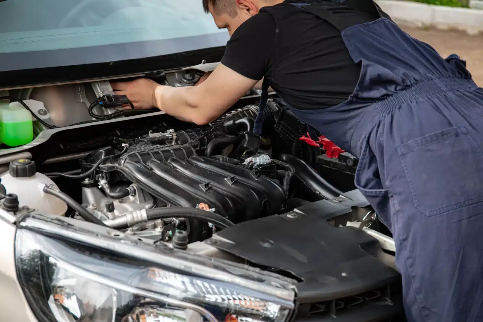 Technicien inspectant le compartiment moteur d'une voiture