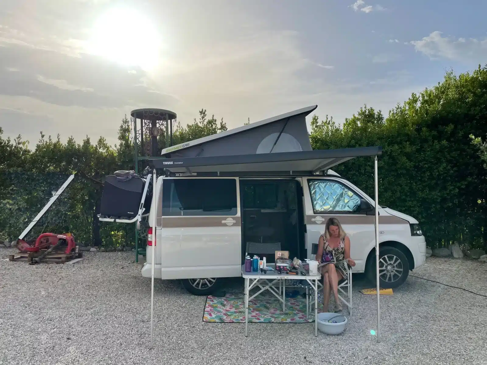 Van aménagé stationné sur une aire de camping-car avec auvent déployé