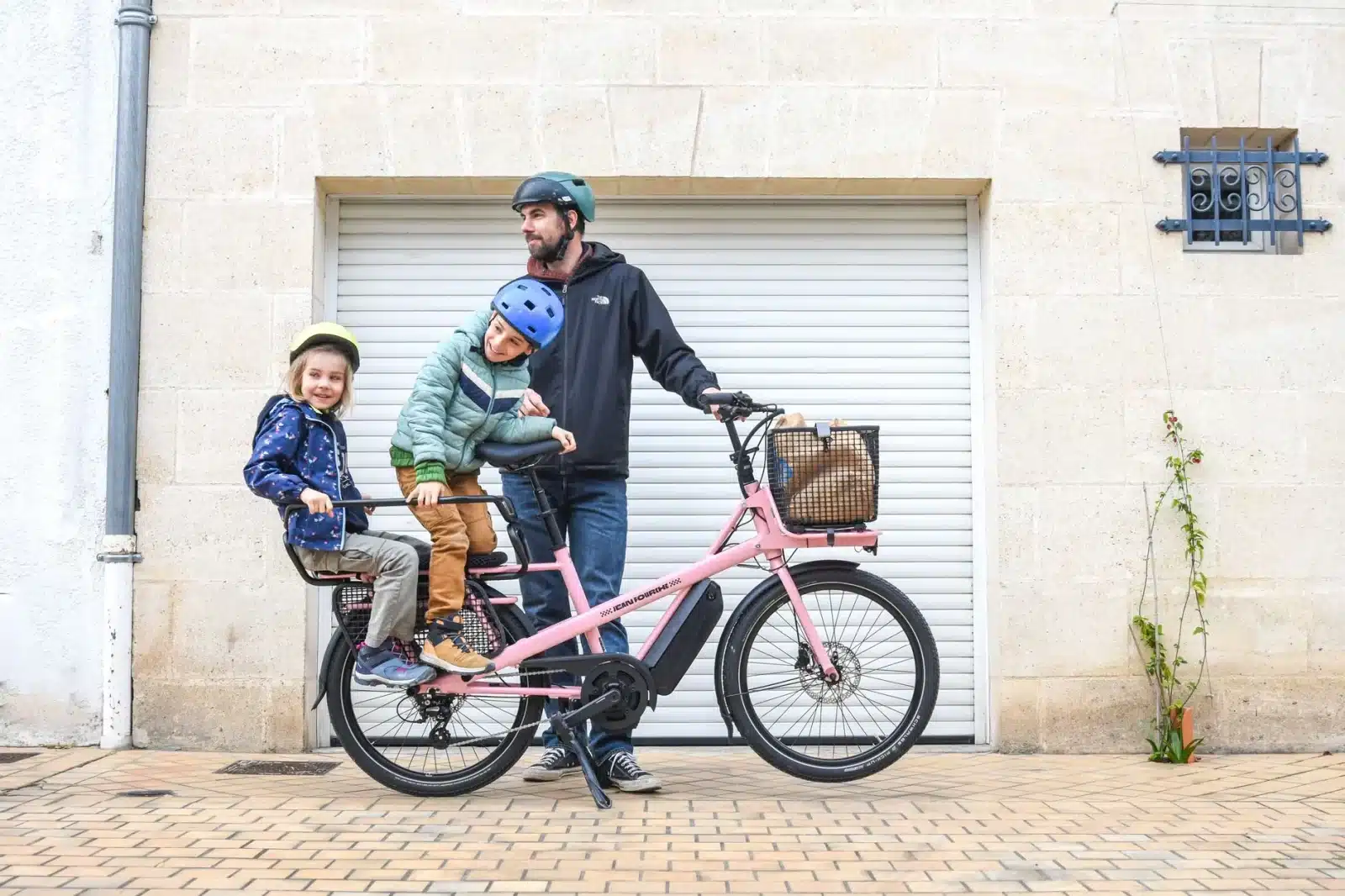 Vélo cargo électrique transportant deux enfants, famille en promenade