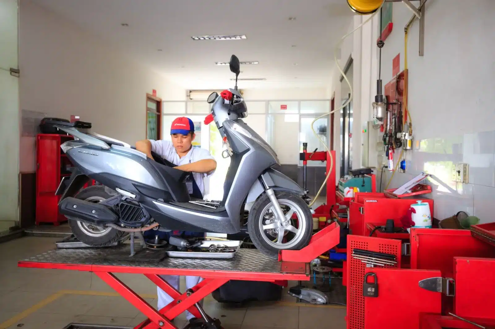 Vélo électrique reconditionné en atelier, technicien vérifiant la batterie