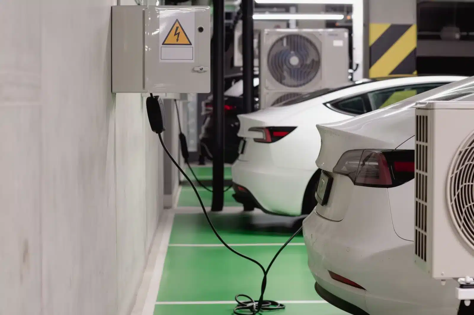 Voiture électrique branchée sur une borne de recharge dans un garage