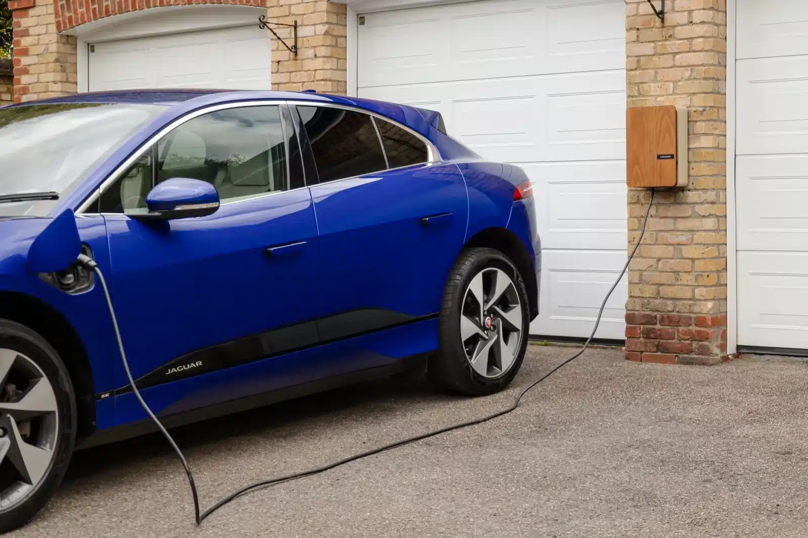 Voiture électrique en charge devant une maison avec des documents administratifs
