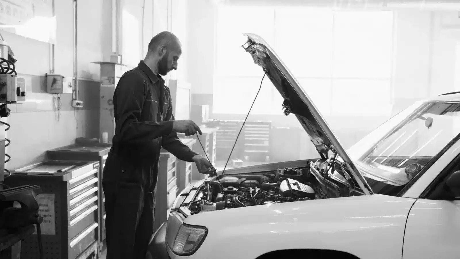 Voiture en panne avec le capot ouvert, inspection du moteur par un mécanicien