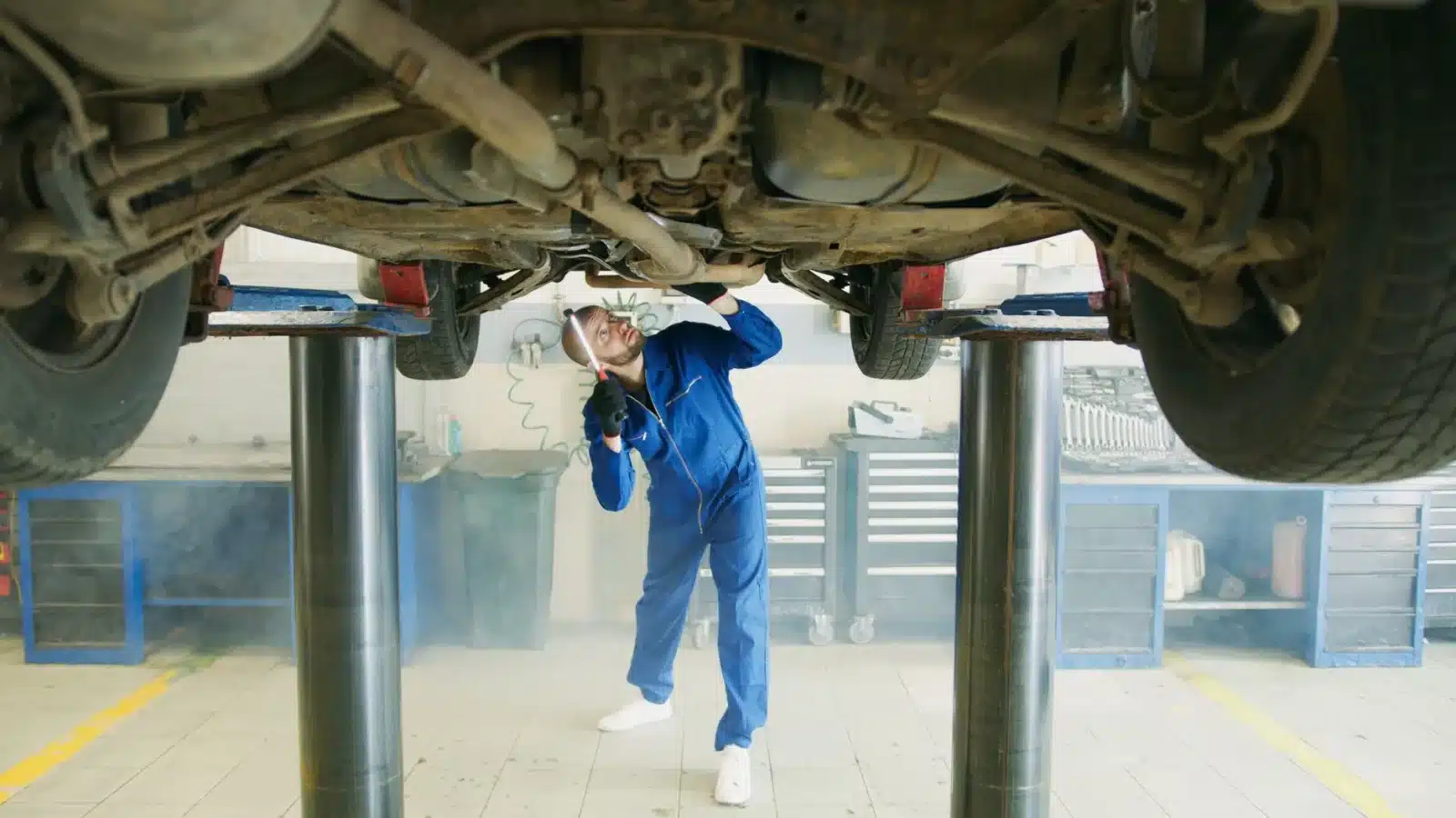 Voiture sur un pont élévateur pendant un contrôle technique en garage