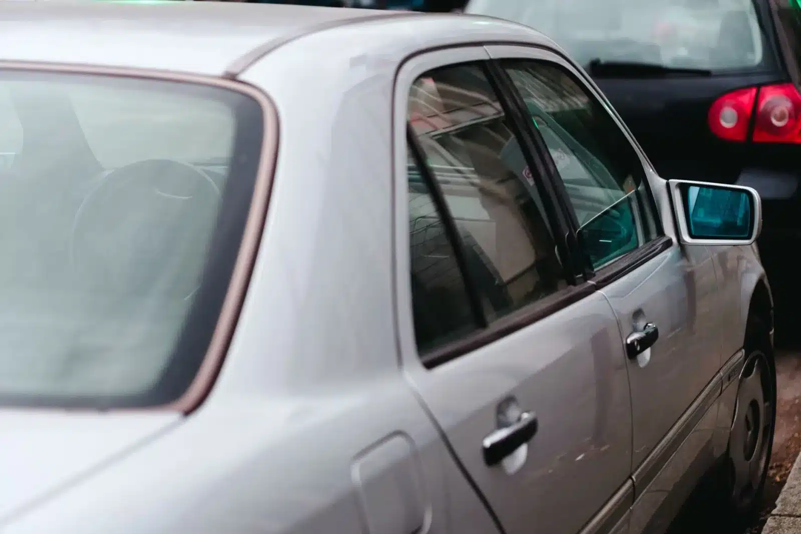 Voiture vandalisée avec une vitre brisée sur un parking