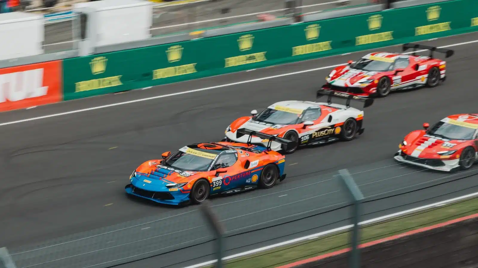 Vue aérienne d'un circuit automobile français avec plusieurs voitures de sport en piste