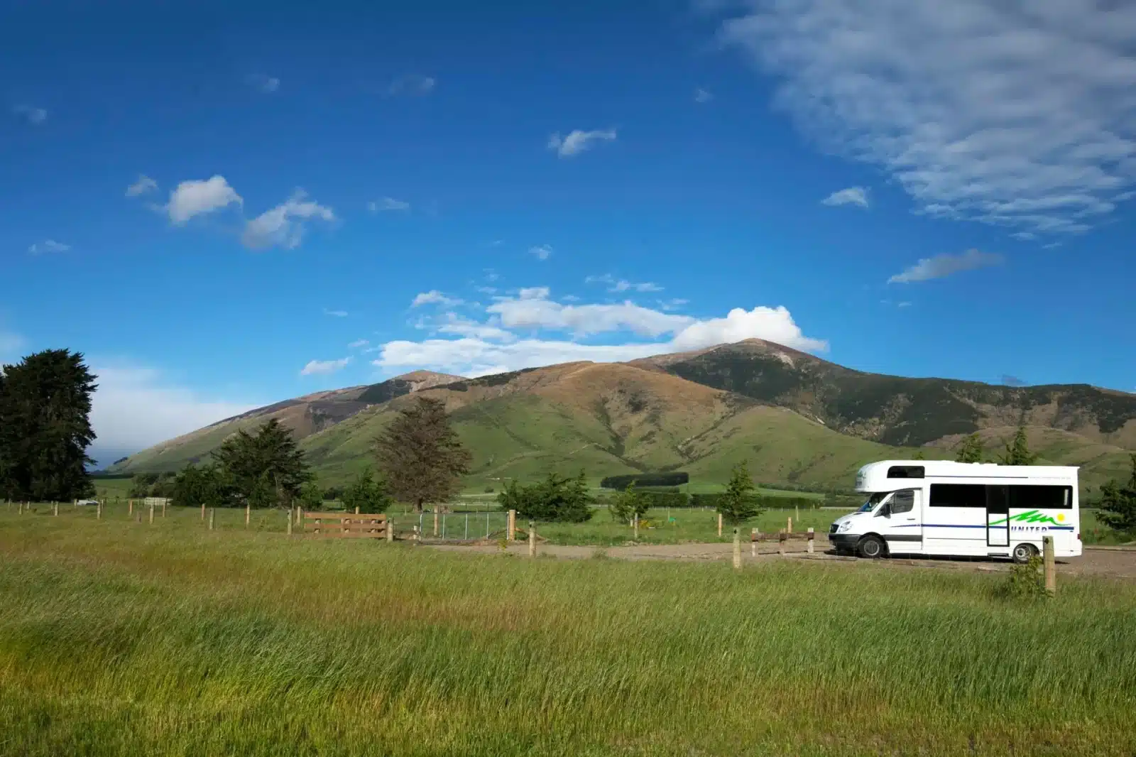 Camping-car d'occasion garé en bord de route avec vue sur les montagnes