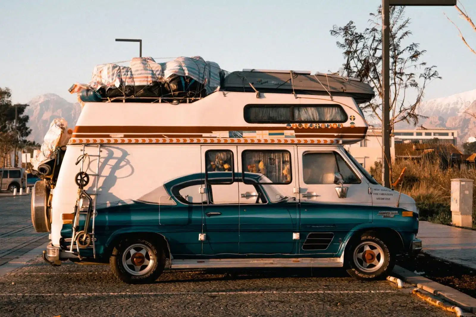 Camping-car stationné dans un vignoble au coucher du soleil, un vigneron accueillant des voyageurs