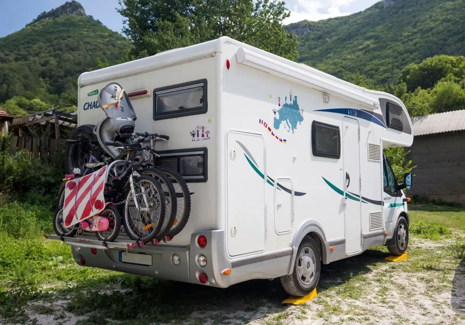 Camping-car stationné en ville avec des vélos fixés sur un porte-vélo arrière
