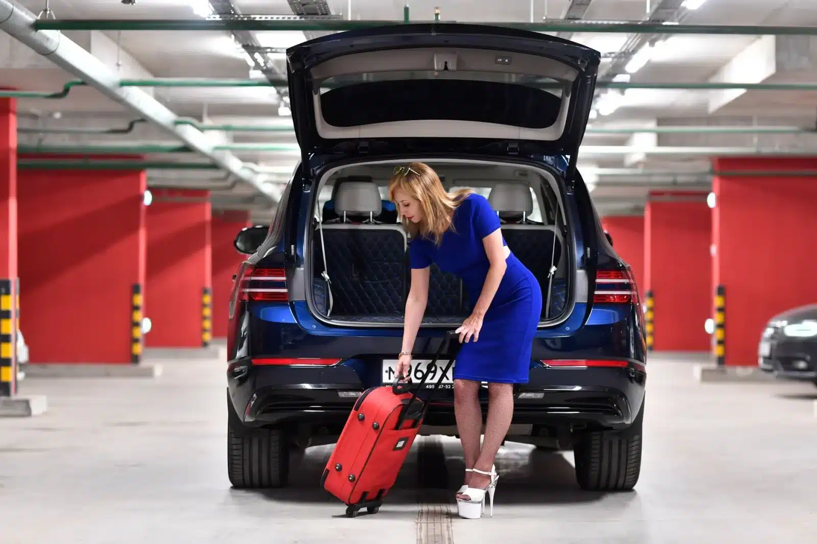 Famille chargeant des bagages dans le coffre d'un SUV loué via une plateforme d'autopartage