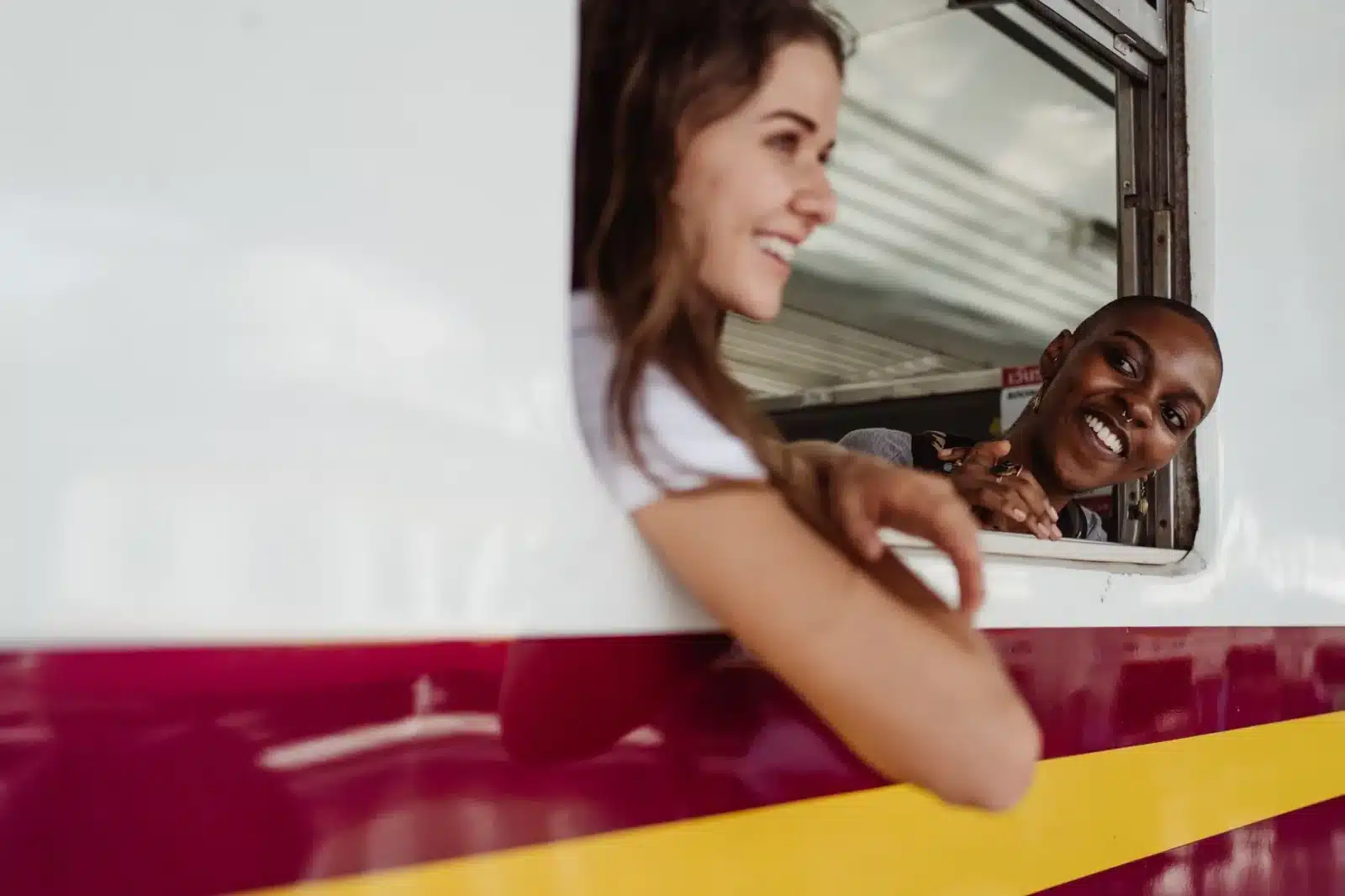 Femme senior souriante regardant par la fenêtre d'un train en mouvement