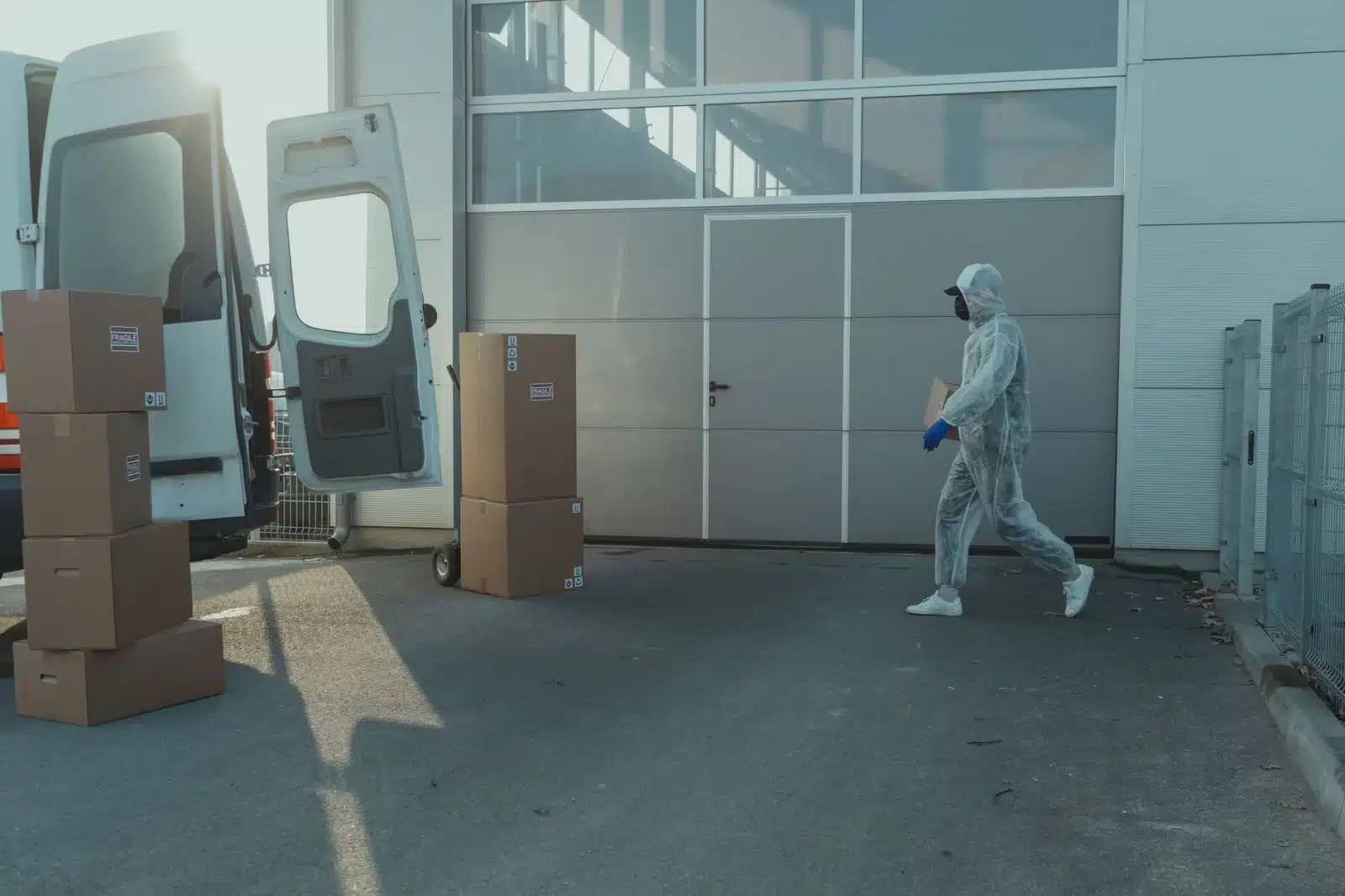 Fourgon blanc immatriculé CTTE avec hayon ouvert, chargé de cartons, sur un parking d’entreprise