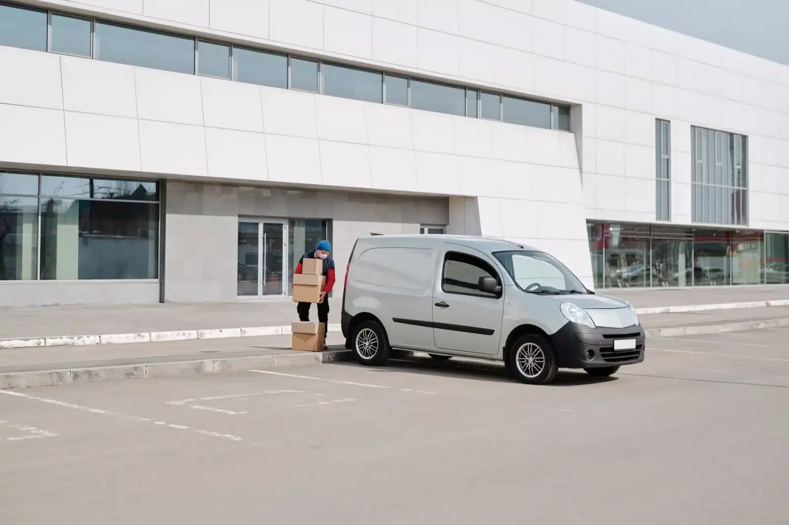 Fourgon Renault Kangoo Master électrique garé en ville avec hayon ouvert et colis à l'arrière