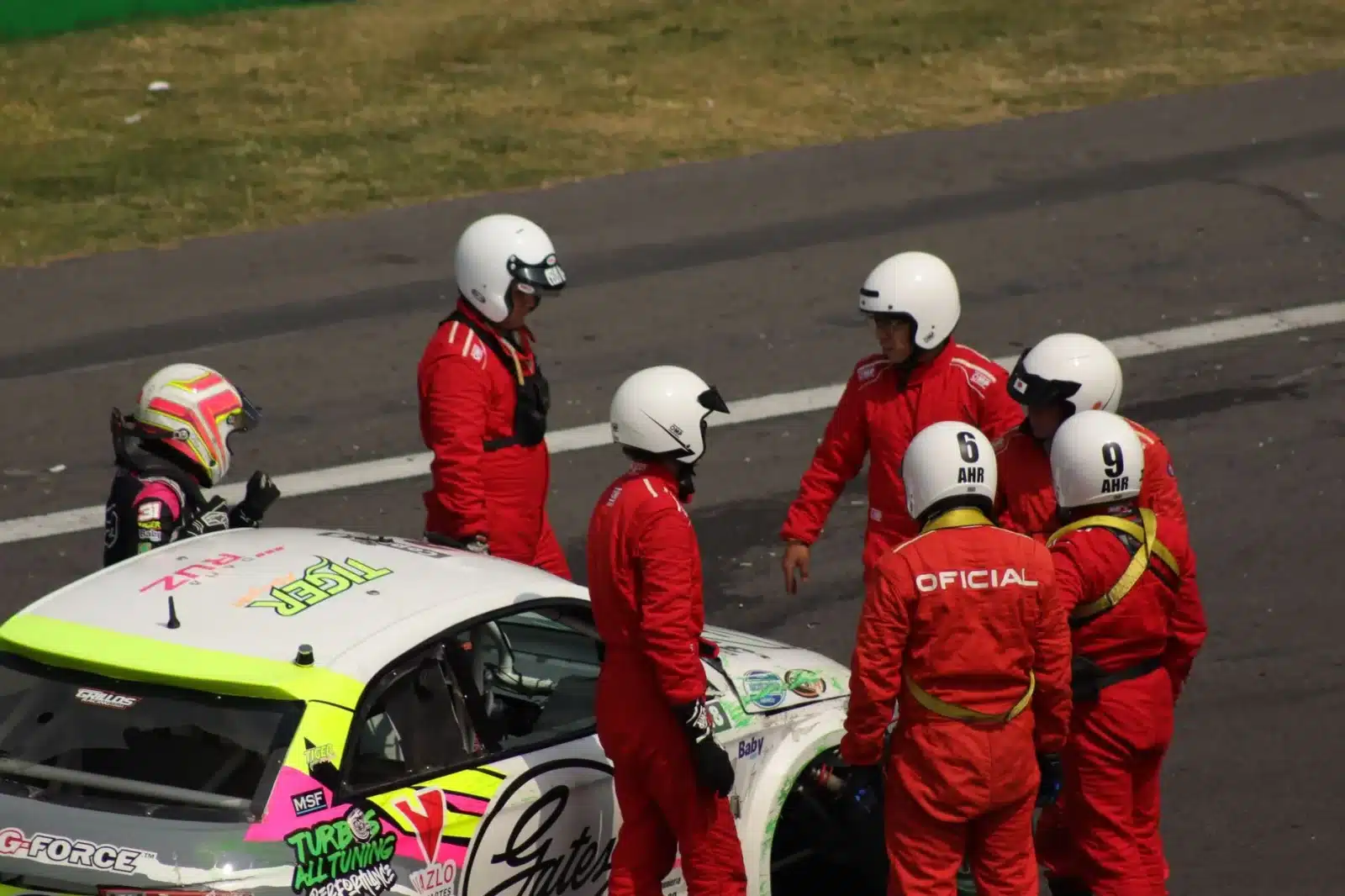 Groupe de pilotes en stage de pilotage avec casques et combinaisons sur un circuit français